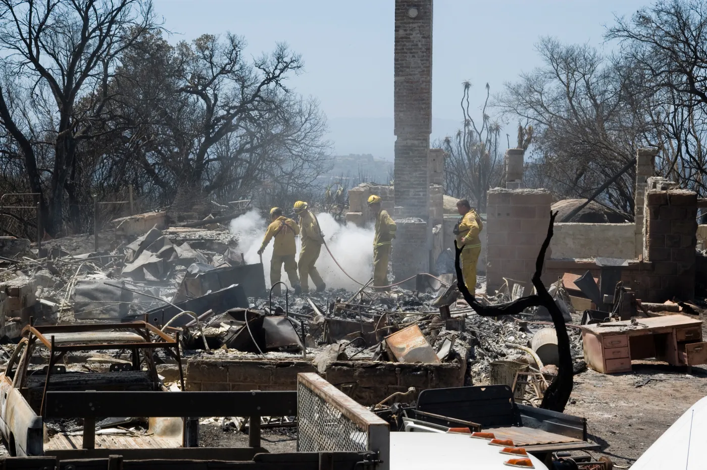 Firefighters put out a hot spot at the Gane House site, after the Jesusita Fire