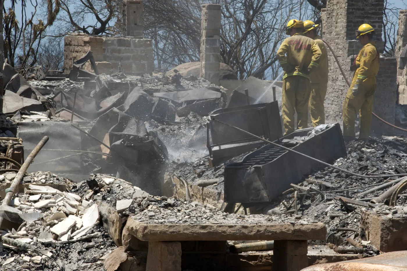 Firefighters put out a hot spot at the Gane House site, after the Jesusita Fire