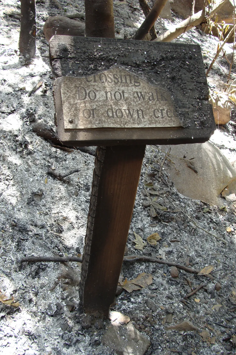 ash and fire debris, burned wood sign at the Mission Creek crossing, after the Jesusita Fire