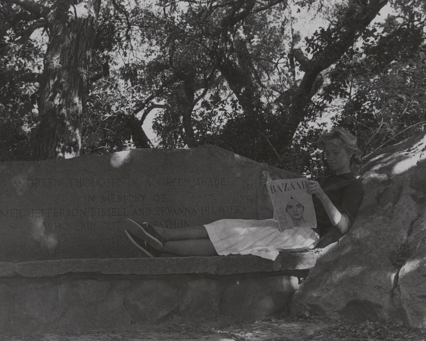 woman reading a magazine on Bissell Bench, stone bench