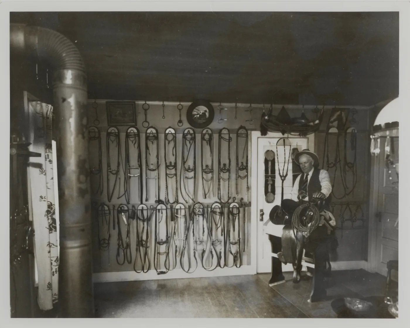 John E.T. (Ted) Whitney, last stage driver on San Marcos Pass standing in tack room in his house on Orchard Ave. in Montecito.