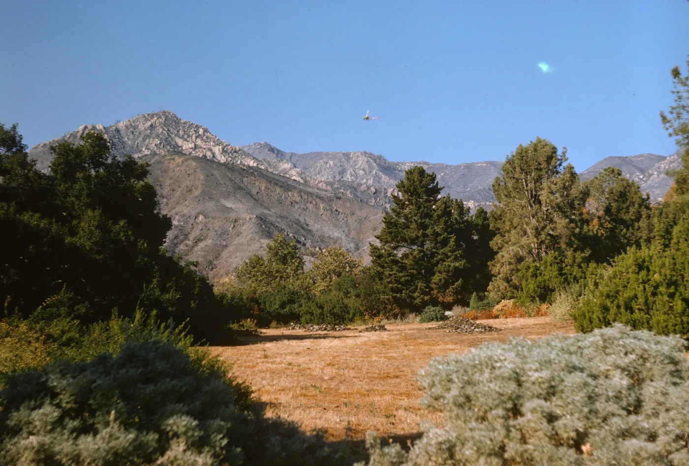 View of helicopter seeding Santa Ynez Mountains after Coyote Fire