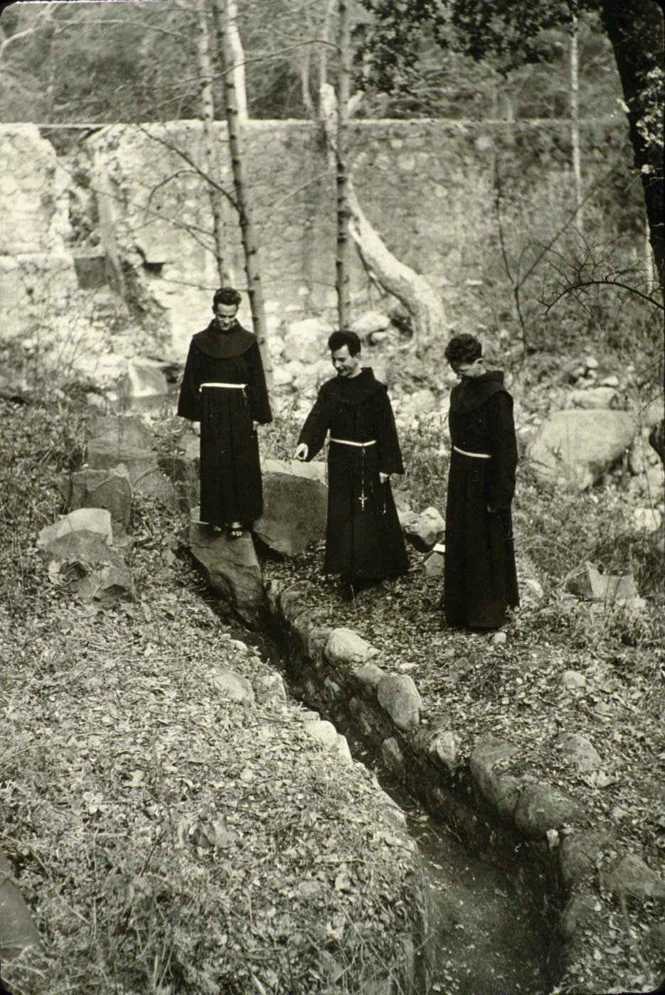 Mission Padres viewing the old Mission Aqueduct, 1940's