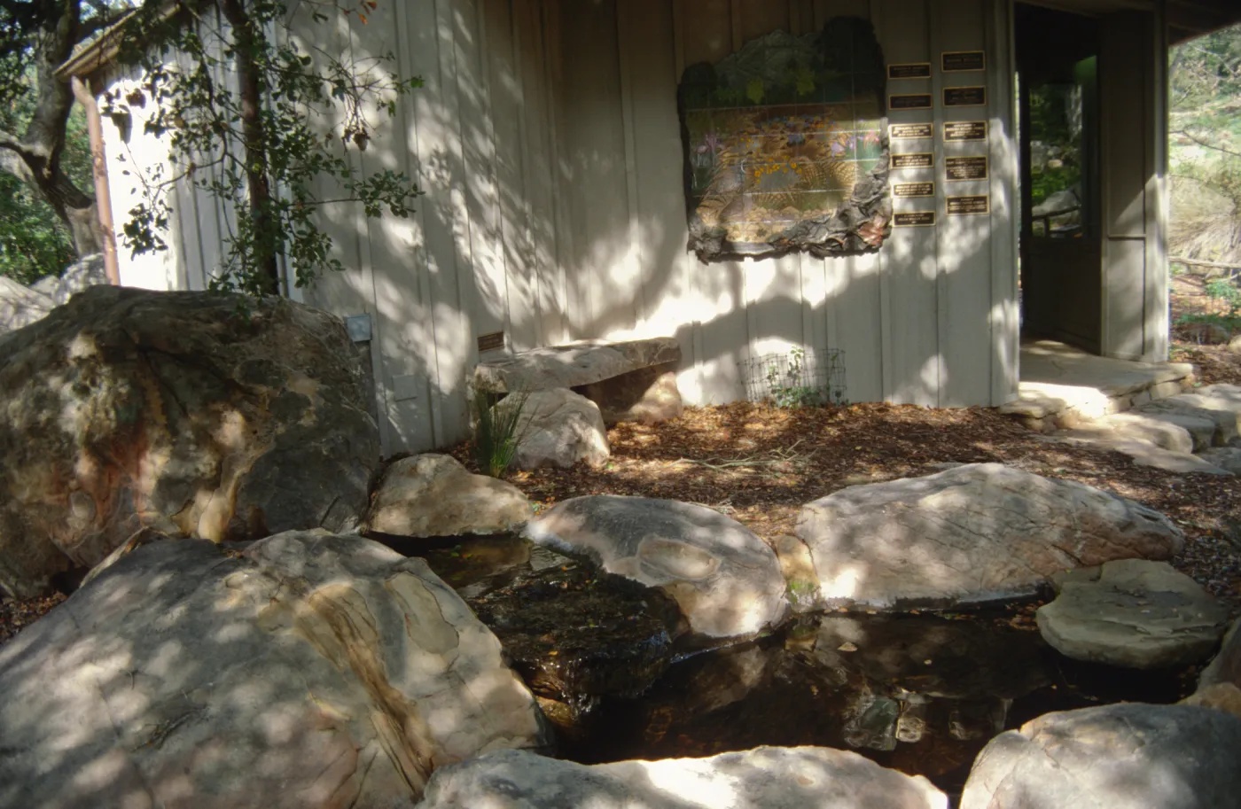 Mosaic on Information Kiosk, stone bench and pond