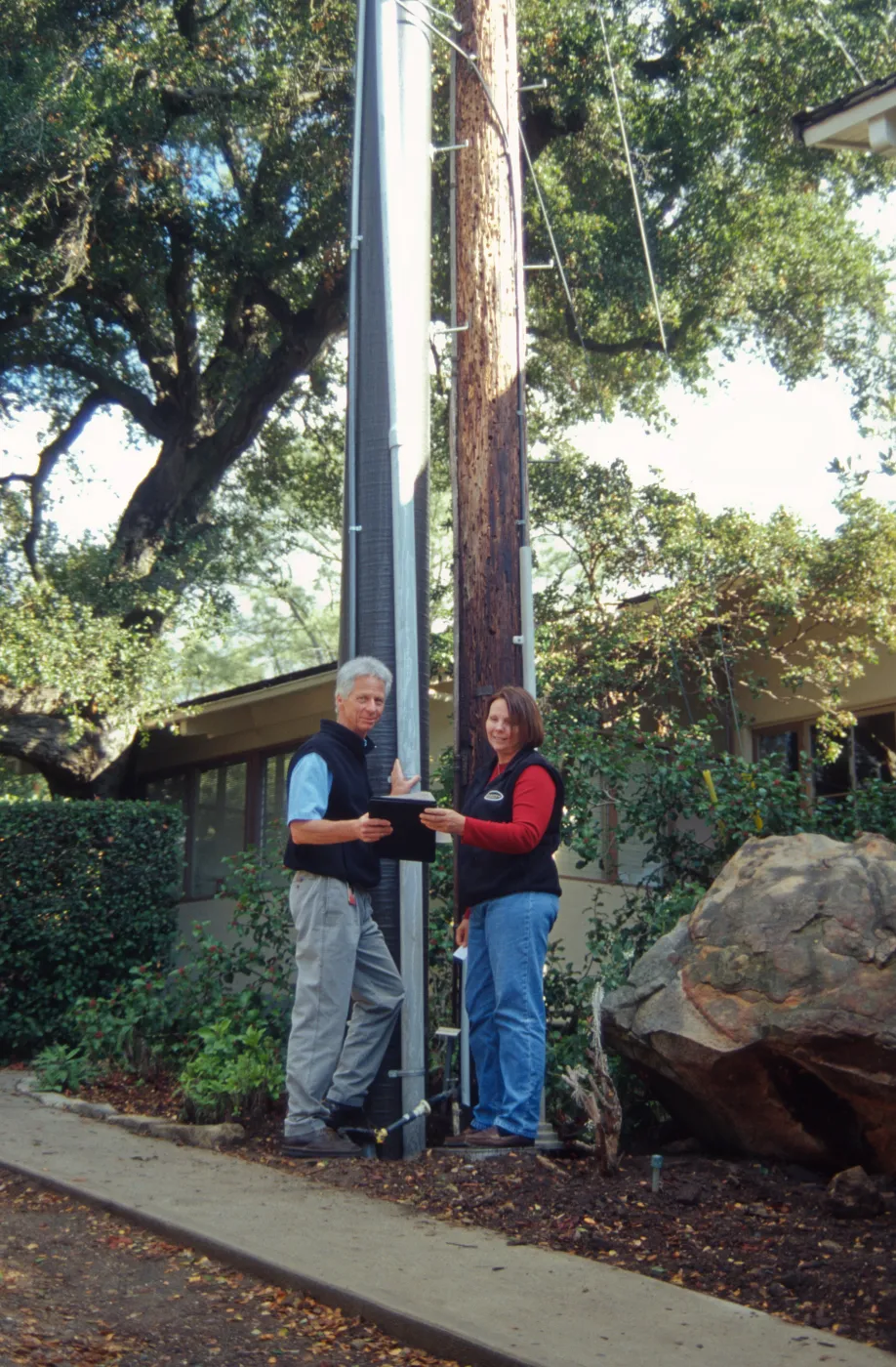New power pole installed adjacent to the old wooden 'acorn granary' pole
