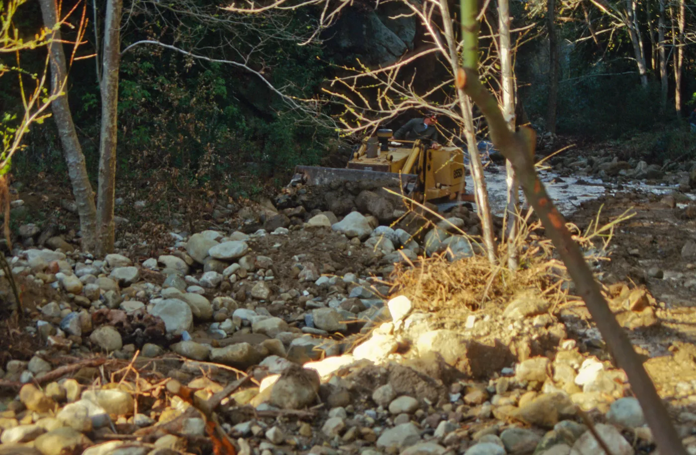 Mission Creek flooded above Mission Dam, with a bulldozer in background