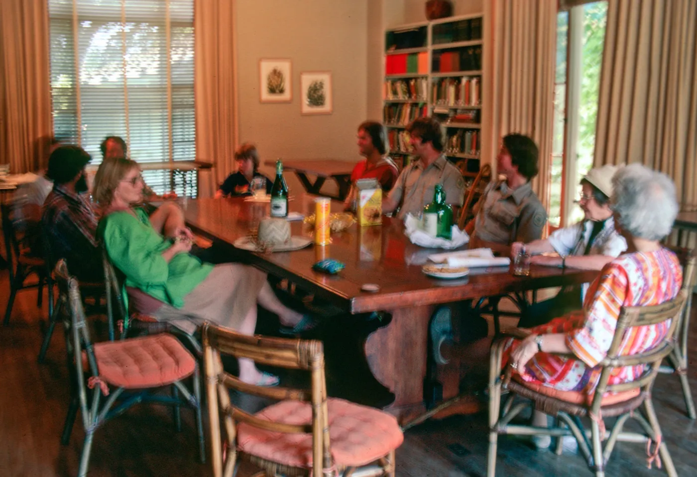 Ten people sit casually around a wooden dining table.