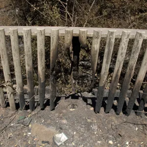 burned fence railing and sign after the Jesusita Fire