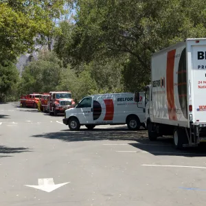 fire trucks and Balfor insurance trucks in the parking lot, after the Jesusita Fire