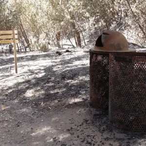 burned trash cans and directional signage along the Canyon Trail, after the Jesusita Fire