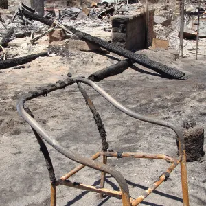 burned chair frame and debris, after the Jesusita Fire