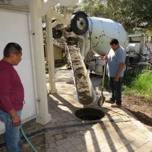 Filling septic tank at entrance with cement slurry