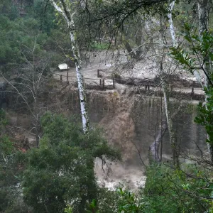 Mission Creek cresting Mission Dam during rainstorm