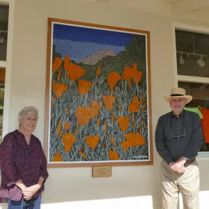 Suzanne and Duncan Mellichamp with â€œAfter the Rainsâ€ mosaic by Patti Jacquemain