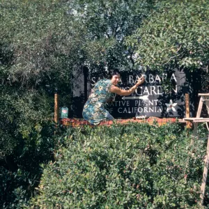 Jacqueline Broughton painting the SBBG entrance sign