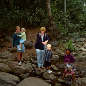 family crossing Mission Creek on boulders at creek crossing