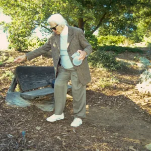 Ann Jones sowing wildflower seeds, Porter Trail, wood bench