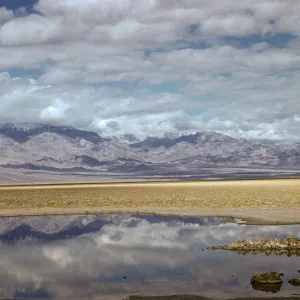 Badwater, mountains and clouds reflected in high desert pool
