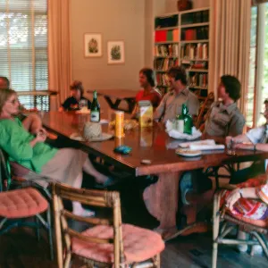 Ten people sit casually around a wooden dining table.