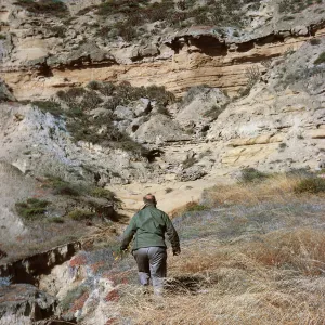 6/ Sam Rainey exploring canyon, 65-126 & SN-43